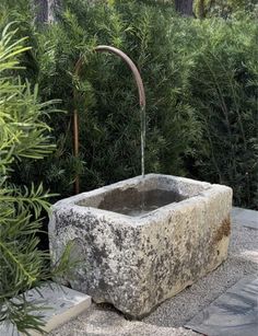 an outdoor fountain with water running from it's faucet to the ground