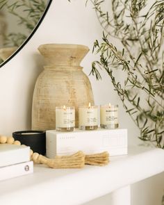 some candles are sitting on a shelf next to a mirror