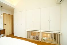 a bedroom with white walls and wooden floors