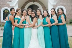 a group of women standing next to each other in front of a building wearing green dresses