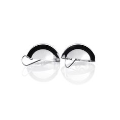 pair of black and white earrings with curved metal ear clips on the ends, against a white background