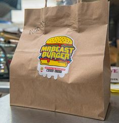 a brown paper bag with a hamburger sticker on it sitting on top of a table