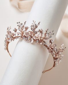 a close up of a napkin with a ring on it and a tiara in the background