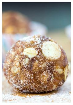 a sugar covered doughnut sitting on top of a table next to muffins