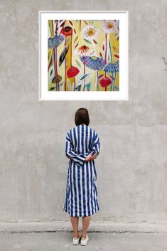 a woman standing in front of a painting on the wall