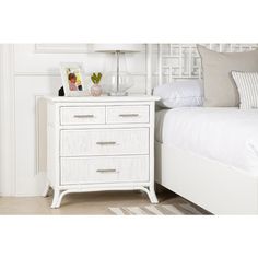 a white bed sitting next to a night stand