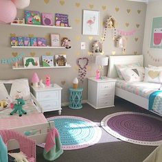 a bedroom with two beds, pink and blue rugs and decorations on the walls