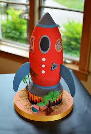 a cake made to look like a rocket ship with trees and plants on the bottom