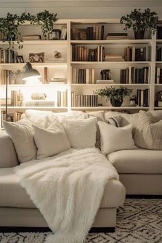 a living room filled with lots of furniture and bookshelves covered in white blankets