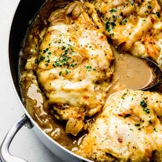 a pan filled with chicken and cheese covered in gravy