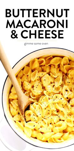 a white bowl filled with macaroni and cheese on top of a table next to a wooden spoon