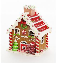 a gingerbread house decorated with candy canes and icing on the roof is shown