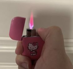 a person holding a pink lighter with a hello kitty sticker on it's side