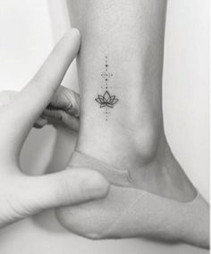 a woman's foot with a small lotus tattoo on the left side of her ankle