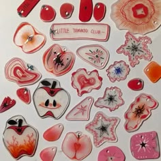 many different types of buttons and magnets on a white surface with the words little tomato club written above them