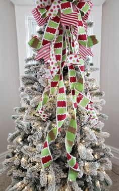 a christmas tree decorated with red, green and white ribbons