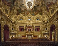 an ornately decorated auditorium with chandeliers and paintings