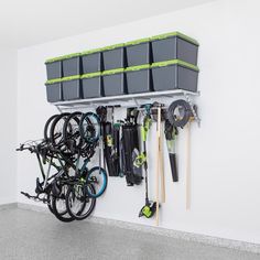 there is a bike hanging on the wall next to some bins and other items