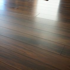 an empty room with hard wood flooring and a dog laying on the floor looking at it