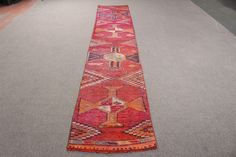 a long red rug on the ground in an area with gray carpet and black walls