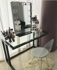 a vanity with a mirror, chair and makeup products on it in front of a window