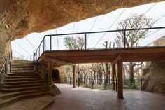 an indoor area with stairs and railings leading up to a cave like structure in the background