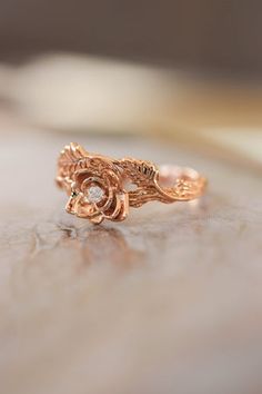 a close up of a rose shaped ring on a table