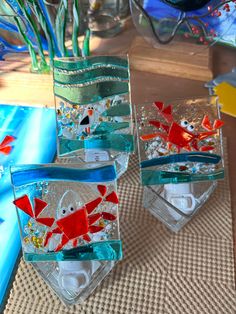 three glass vases with fish in them on a table