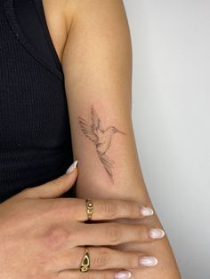 a woman's arm with a bird tattoo on it