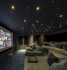 a home theater with couches and projector screen in the middle of the room