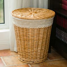 a wicker basket sitting on the floor next to a window