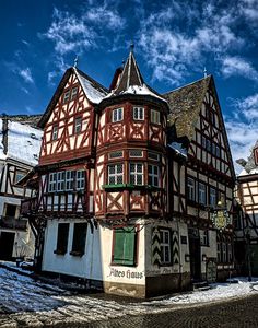 an old building with red and white paint on it's side in the snow