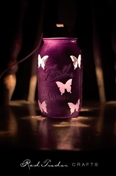 a purple mason jar with butterflies painted on it