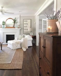 a living room filled with furniture and a fire place under a mirror on the wall