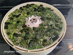 a food processor filled with green vegetables on top of a stove