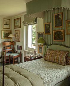 a bed sitting in a bedroom next to a window with pictures on the wall above it