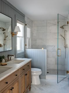 a bathroom with two sinks, a toilet and a walk in shower next to each other