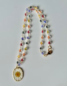 a long necklace with a flower on it