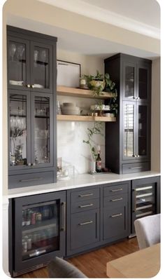 a kitchen with gray cabinets and white counter tops, along with a dining room table