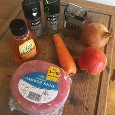 the ingredients to make an apple cider are displayed on a cutting board, including carrots, apples, and sausage