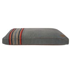 a dog bed with a striped pillow on the front and bottom side, in grey