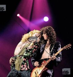 two people on stage with guitars in their hands