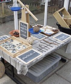 a table that has some items on it and is set up with chalkboard signs