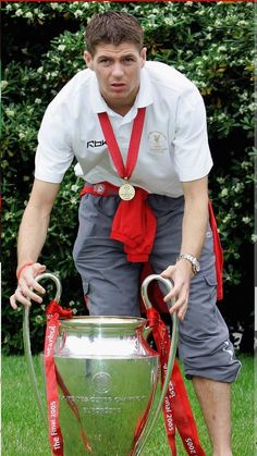 a young man is holding the trophy in his hands