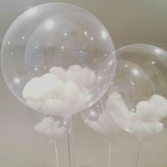 three clear balloons with clouds floating in them