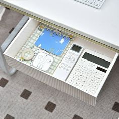 a white desk with a calculator, phone and keyboard