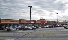 cars are parked in the parking lot at an empty shopping center on a cloudy day