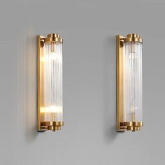 two gold wall lights with glass panels on the side and one light is turned on