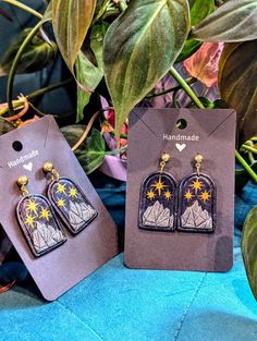 Elevate your wardrobe with our handmade Night Court earrings, each pair a unique embodiment of artistic craftsmanship and elegant design. These lightweight, chic earrings are perfect for any occasion, featuring the iconic Night Court symbol of a mountain with three stars above the main peak. Their deep, celestial hues and intricate detailing offer a modern twist on classic elegance, allowing you to express your love for the enchanting ACOTAR world. Ideal for both day and evening wear, they add a touch of magical sophistication and otherworldly charm to any ensemble. 💠Why choose our polymer clay earrings? 💠 ✦ Lightweight for all-day comfort ✦ Unique, handcrafted designs with a focus on details ✦ Please note, due to the handmade nature, colors may vary slightly 💠Shipping: We aim to ship w Acotar Earrings, Acotar World, Night Court Symbol, Earrings Handmade Clay, Mountain Earrings, Handmade Clay Jewelry, Night Court, Chic Earrings, Handmade Clay