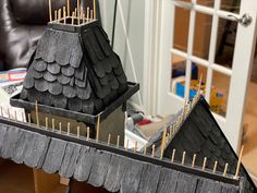 two model houses with sticks sticking out of the roof and on top of each other